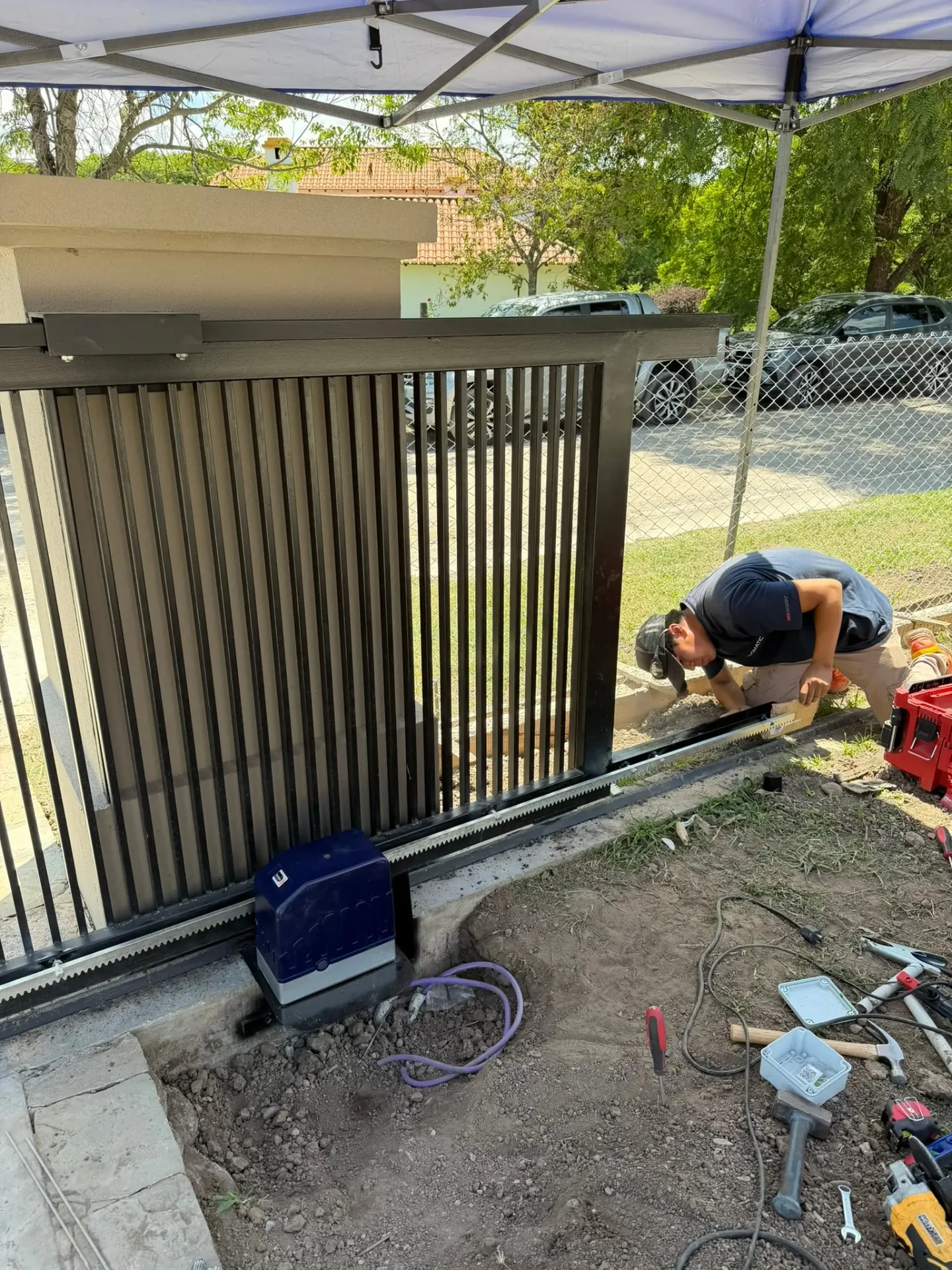 Técnico realizando mantenimiento y lubricación en motor de portón automático