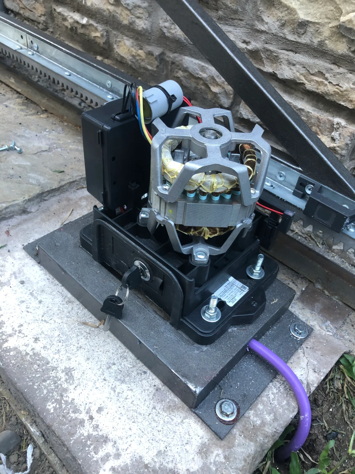 Motor de automatización instalado junto a la cremallera y la guía de un portón corredizo